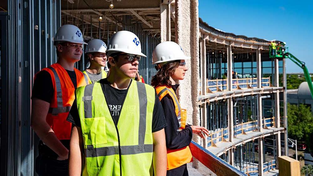 People wearing 澳门足彩app hard hats on a construction site.